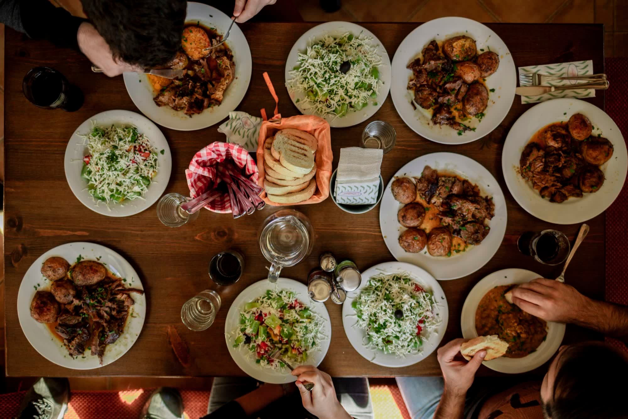 A generous trattoria table full of shared dishes, seen from above