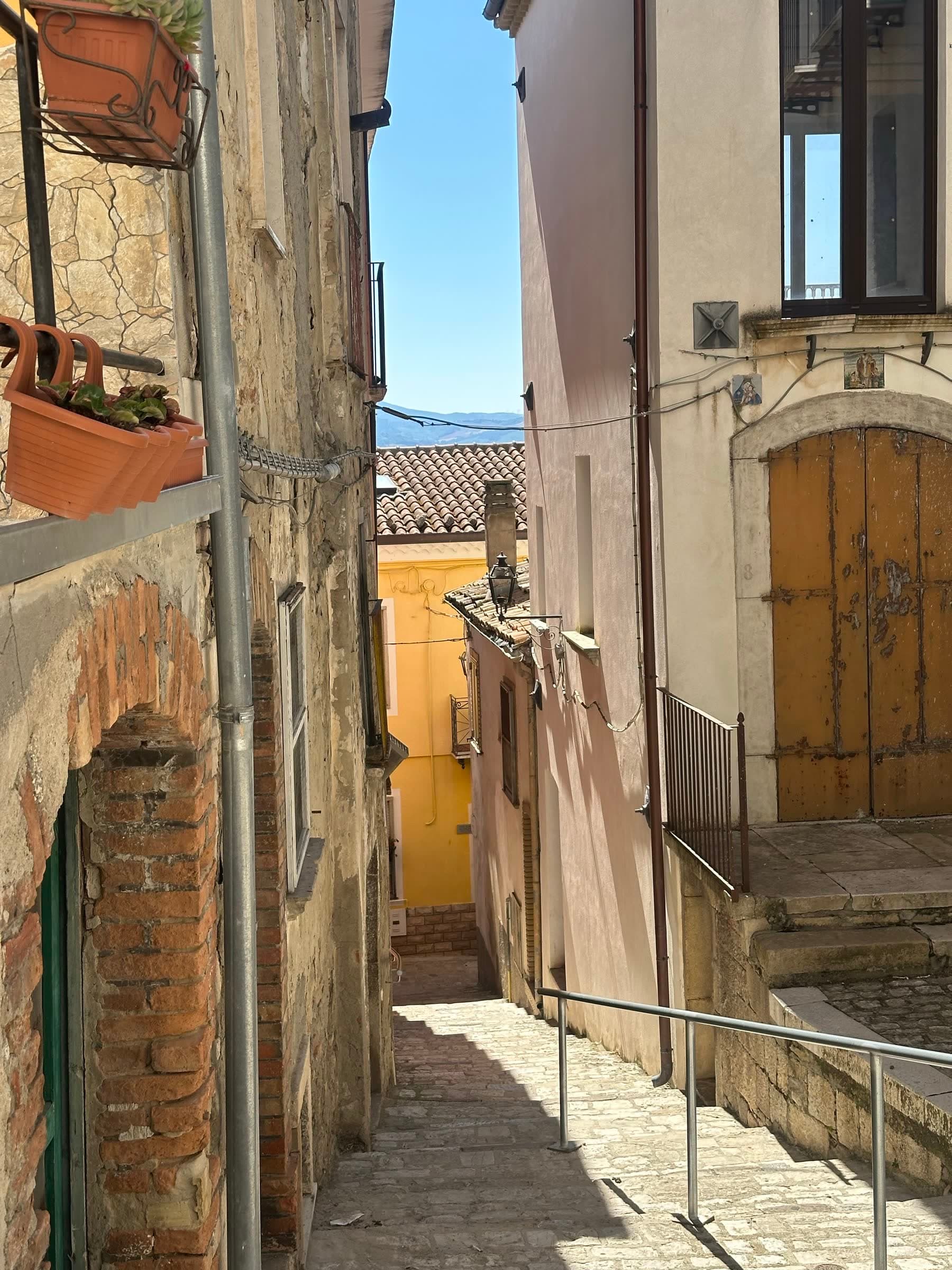A sunlit alley between stone houses in Macchia Valfortore